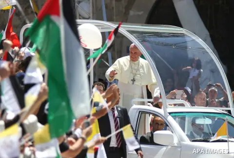 Pope Francis waves to the crowd as he arrives to give Mass at Manger Square, outside the Church of Nativity in the West Bank town of Bethlehem, May 25, 2014. Pope Francis on Sunday invited the Israeli and Palestinian pre...