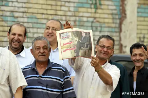 Egyptians queue outside a polling station in Cairo on May 26, 2014. Egyptians begin voting in a new presidential election which ex-army chief Abdel Fattah al-Sisi, who ousted the elected Islamist leader, is expected to e...