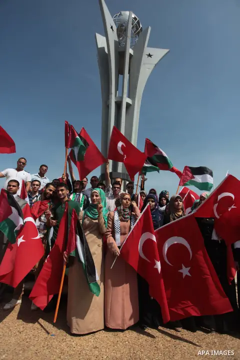 Palestinian women hold a Turkish flag during a rally ahead of the 4th anniversary of the Mavi Marmara Gaza flotilla incident, at the seaport of Gaza City May 29, 2014. Nine activists, eight Turkish and one Turkish-Americ...