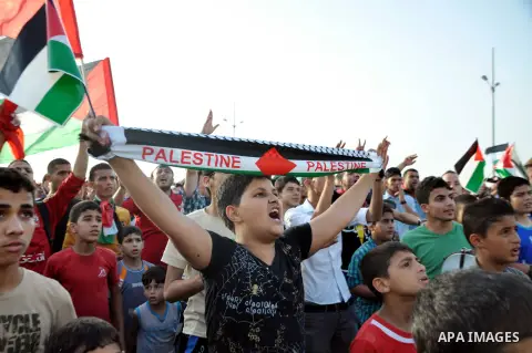Palestinians watch the match between their national team and the Philippine team during the final of the AFC Challenge Cup in Maldives, in Gaza City on May 30, 2014. Photo by Mohammed Talatene
