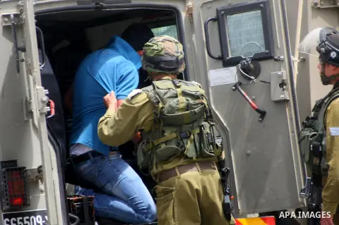 Israeli soldiers detain a photographer during a protest in support of Palestinian prisoners on hunger strike in Israeli jails at the al-Aroub Palestinian refugee camp, just north the West Bank town of Hebron on May 31, 2...