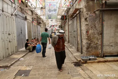 Palestinians walk past a closed shop during a strike to solidarity with Palestinian prisoners on hunger strike held in Israeli jails, in the West Bank city of Nablus on June 1, 2014. Photo by Nedal Eshtayah