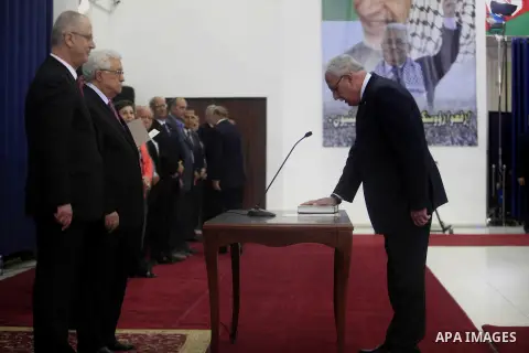 Palestinian Foreign Minister Riyad Al-Maliki is sworn in along with the new Palestinian unity government in the presence of Palestinian president Mahmud Abbas (L) in the West Bank city of Ramallah June 2, 2014. Abbas hai...