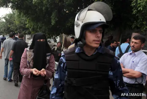 Palestinian employees paid by Palestinian Authority stand outside the Palestine Islamic Bank as they wait to receive their salaries, in Gaza city on June 5, 2014. A Palestinian unity government formed by President Mahmou...