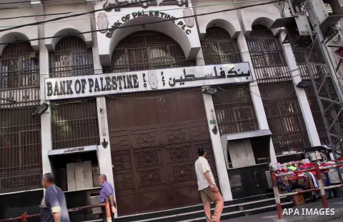 Palestinians walk past a closed bank after a scuffle with employees appointed by Hamas since 2007, in Gaza City June 8, 2014. A Palestinian unity government formed by President Mahmoud Abbas and the Islamist Hamas group...