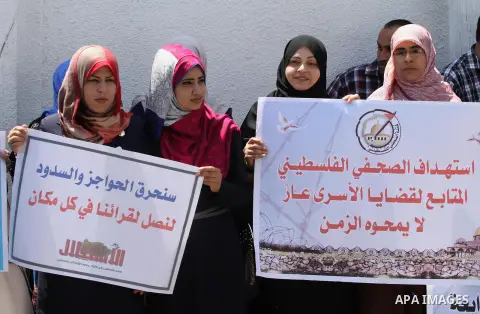 Palestinian journalists carry placards during a protest in solidarity with Palestinian journalists in the West Bank, in Gaza city, on June 12, 2014. Photo by Mohammed Asad
