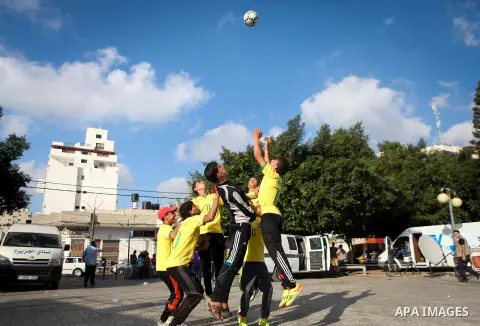 Palestinian youth take part in a football match during a protest against the Israeli blockade on Gaza Strip, in Gaza City on June 12, 2014. Palestinians share a billion or more people around the globe the feeling of anti...