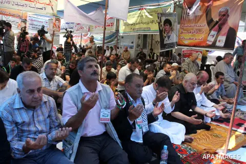 Palestinians take part in a Friday prayer in front of Red Cross office in support of 125 Palestinian prisoners detained in Israeli jails and who have been on hunger strike for 52 days, in Gaza City on June 13, 2014. Some...