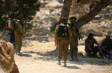 Israeli soldiers arrest Palestinians as they secure the area near the West Bank city of Hebron June 13, 2014. Israeli forces are searching for three Jewish teenagers who went missing in the occupied West Bank late Thursd...
