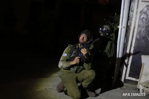 Israeli soldiers take positions during a raid in the West Bank refugee camp of Jalazon, north of Ramallah, early on June 16, 2014. The army says more than 150 Palestinians have been arrested in the search for the three y...