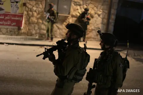 Israeli soldiers take positions during a raid in the West Bank refugee camp of Jalazon, north of Ramallah, early on June 16, 2014. The army says more than 150 Palestinians have been arrested in the search for the three y...