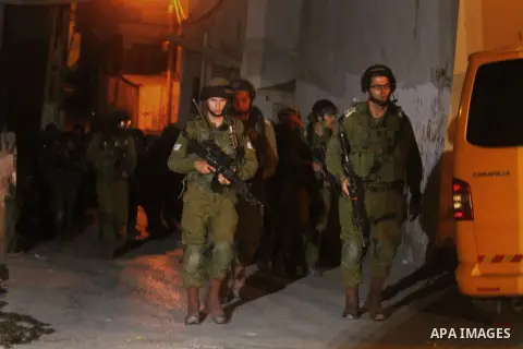 Israeli soldiers take positions during a raid in the West Bank refugee camp of Jalazon, north of Ramallah, early on June 16, 2014. The army says more than 150 Palestinians have been arrested in the search for the three y...