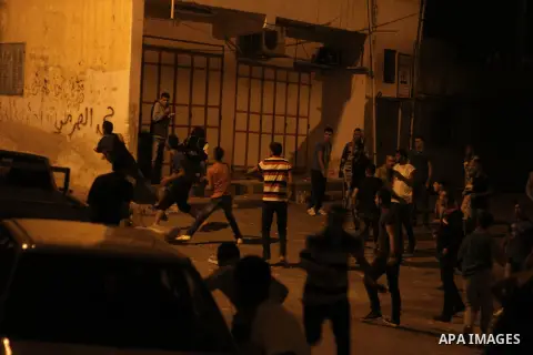 Palestinians throw stones towards Israeli soldiers during street confrontations in the West Bank refugee camp of Jalazon, north of Ramallah, early on June 16, 2014. The army says more than 150 Palestinians have been arre...
