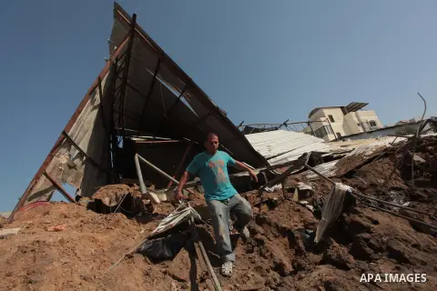 Palestinians inspect the rubble of a destroyed metal workshop after it was hit by an Israeli missile strike in Gaza City, early Tuesday, June 17, 2014. In the Gaza Strip, Israeli warplanes struck three weapons manufactur...