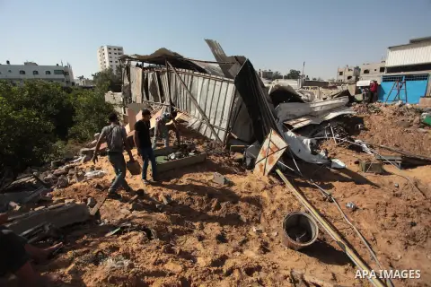 Palestinians inspect the rubble of a destroyed metal workshop after it was hit by an Israeli missile strike in Gaza City, early Tuesday, June 17, 2014. In the Gaza Strip, Israeli warplanes struck three weapons manufactur...