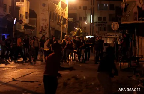 Palestinian youhts throw stones at Israeli soldiers as they patrol the streets during an operation in the West Bank city of Ramallah on June 17, 2014 as Israeli forces broadened the search for three teenagers believed ki...