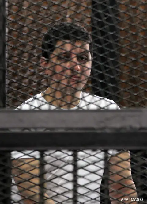 Egyptian Muslim Brotherhood members stand inside the defendants cage during their trial in the capital Cairo on June 17, 2014. The court postponed to July 23 the verdict in the trial of Muslim Brotherhood Supreme Guide M...