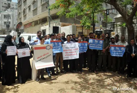 Palestinian journalists hold placards during a demonstration to protest against the closure of the al-Aqsa radio station and TV channel in the West Bank by Israeli security forces, in Gaza City on June 19, 2014. Overnigh...