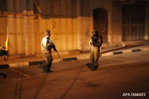 Israeli soldiers surround the Islamic Charitable Society as Israeli jeeps enter the building due to suspected links with Hamas on June 20, 2014 in the West Bank town of Hebron. Computers and numerous files were seized be...