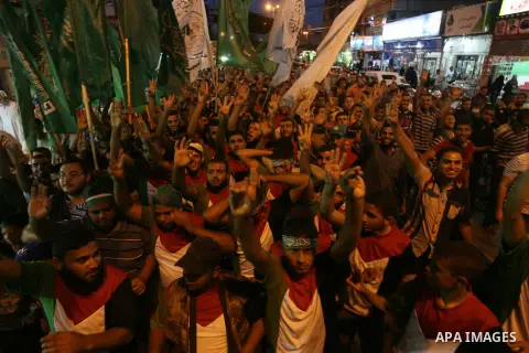 Palestinians raise hand gestures including three raised fingers, a sign of their support for the recent abduction of three missing Israeli teens, during a rally to express solidarity with Palestinian prisoners on hunger...