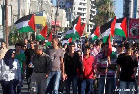 Palestinians shout slogans during a demonstration against the newly cooperation between the Palestinian police with the Israeli police to find three missing Israeli teenagers in the center of the West Bank city of Ramall...