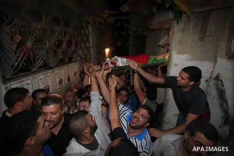 Palestinians carry the body of Mostafa Aslan, 24, during his funeral in the West Bank city of Ramallah on June 25, 2014. was pronounced dead from wounds he sustained during clashes with Israeli soldiers in Qalandiya refu...