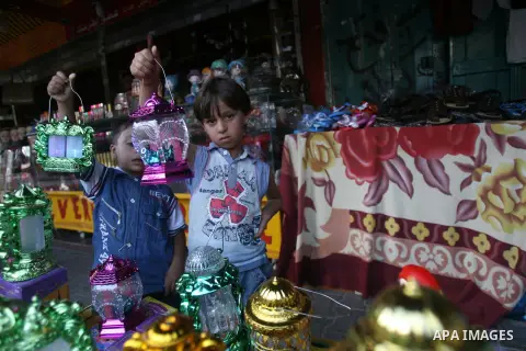Palestinian children carry traditional Ramadan lanterns marking the holy month of Ramadan at a market in Rafah in the southern Gaza Strip, June 26, 2014. Muslims observe the dawn-to-dusk fasting during the holy month of...