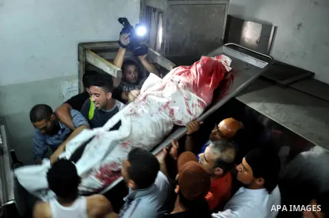 Palestinians mourn around the body of a Palestinian militants at a hospital morgue in Gaza City June 27, 2014. An Israeli air strike killed two Palestinian militants and critically wounded a third in the Gaza Strip on Fr...