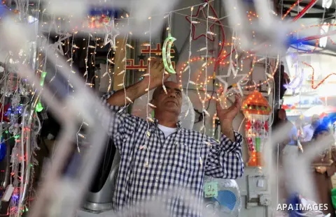A Palestinian man sells decore lights in his shop at a market in the West Bank City of Ramallah, as Muslims prepare for the upcoming holy fasting month of Ramadan, on June 28, 2014. on the eve of the start of the Muslim...