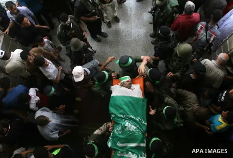 Palestinian members of Hamas' armed wing carry the body of their comrade Mohammed Ebeid during his funeral in Deir El-Balah in the central Gaza Strip June 30, 2014. Israeli forces attacked militant targets in the Gaza St...