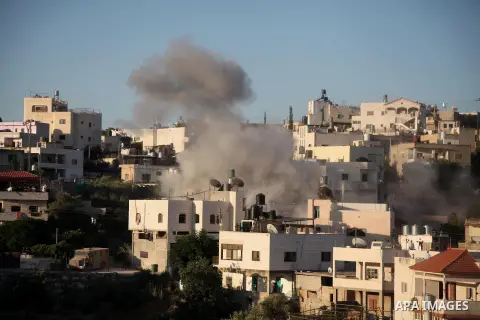 Smoke rises from a building of Palestinian Ziad Awad in the village of Idhna, close to the city of Hebron in the southern West Bank July 2, 2014. Israel on Wednesday demolished the home of Awad, who was arrested this mon...