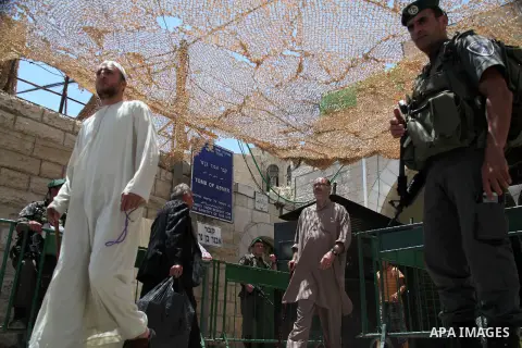 Israeli policemen stand guard as Palestinian muslims arrive at Ibrahimi mosque "Sanctuary of Abraham", to the traditional Friday prayers, the first of Islam's holy month of Ramadan, in the West Bank City of Hebron July 0...