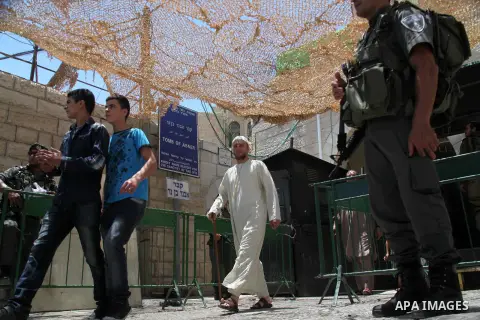 Israeli policemen stand guard as Palestinian muslims arrive at Ibrahimi mosque "Sanctuary of Abraham", to the traditional Friday prayers, the first of Islam's holy month of Ramadan, in the West Bank City of Hebron July 0...