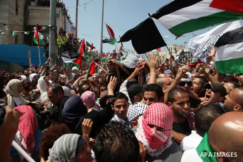 Palestinian mourners carry the body of Mohammed Abu Khder, 16, during his funeral in Shuafat, in Israeli annexed East Jerusalem on July 4, 2014. Abu Khder, a Palestinian teenager was reportedly kidnapped and killed, trig...