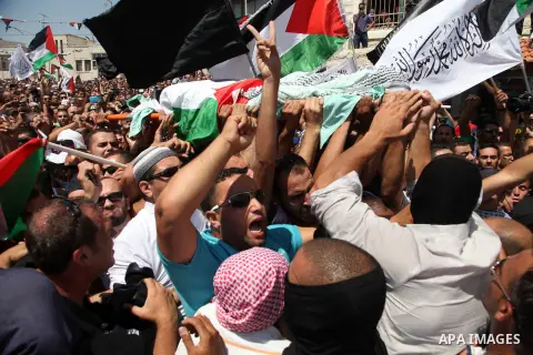 Palestinian mourners carry the body of Mohammed Abu Khder, 16, during his funeral in Shuafat, in Israeli annexed East Jerusalem on July 4, 2014. Abu Khder, a Palestinian teenager was reportedly kidnapped and killed, trig...