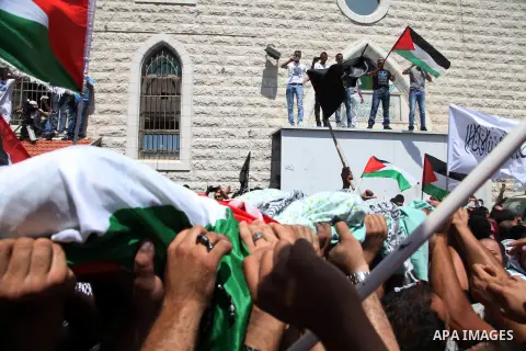 Palestinian mourners carry the body of Mohammed Abu Khder, 16, during his funeral in Shuafat, in Israeli annexed East Jerusalem on July 4, 2014. Abu Khder, a Palestinian teenager was reportedly kidnapped and killed, trig...