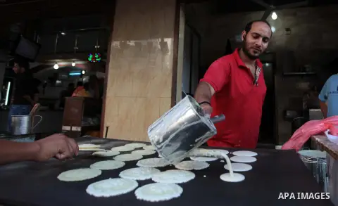 A Palestinian vendor prepares traditional pancakes known as ''Qatayef'' during the holy fasting month of Ramadan in Gaza city, on July 0, 2014. Muslims around the world refrain from eating, drinking and sexual intercours...
