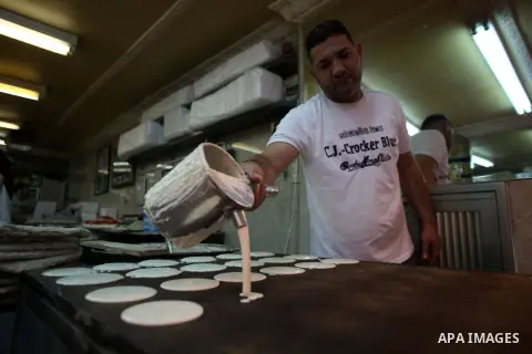 A Palestinian sweet maker prepares pancake called "katayef" on the seventh day of Ramadan, the holy fasting month, in Jerusalem old city on July 5, 2014. Muslim believers abstain from eating, drinking, smoking and having...