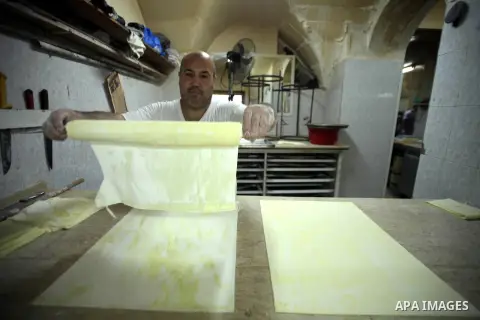 A Palestinian man prepares traditional sweets "Baklava" during the seventh day of the holy fasting month of Ramadan, in Jerusalem old city, on July 5,, 2014. Muslim believers abstain from eating, drinking, smoking and ha...