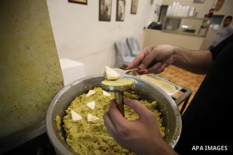 A Palestinian man prepares traditional foods as "Falafel" during the seventh day of the holy fasting month of Ramadan, in Jerusalem old city, on July 5,, 2014. Muslim believers abstain from eating, drinking, smoking and...