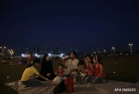 A Palestinian family eats breakfast during the holy month of Ramadan at Gaza port in Gaza city on July 5, 2014. During Ramadan, muslims around the world are observing the holy fasting month of Ramadan in which they refra...
