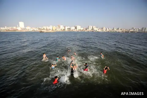 Palestinian boys swim in the port in Gaza City on July 6, 2014. Israel decided on July 6, 2014 to reduce the fishing zone open for Gaza fishermen from 6 nautical miles to 3 (5.6 km). Photo by Ezz Zanoun