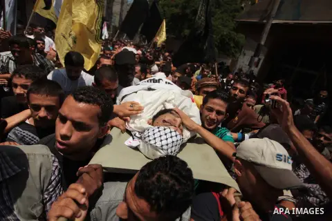 Mourners carry the body of Palestinian militant Marwan Sleem during his funeral in the central Gaza Strip July 7, 2014. Israel killed two Palestinian militants, one of them Sleem, and wounded a third in one of about a do...