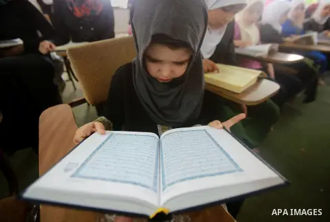 Palestinian girls read Qur'an at an educational institution during the holy fasting month of Ramadan, in the West Bank city of Nablus on July 08, 2014. Muslims around the world refrain from eating, drinking and sexual in...