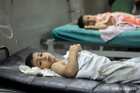 A Palestinian whom medics said was wounded in an Israeli air strike, lies on a bed at a hospital in Gaza City July 9, 2014. At least 23 people were killed across Gaza, Palestinian officials said on Wednesday, by a bombar...
