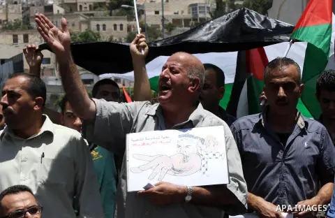 Palestinians hold banners in a protest against Israeli aggression on Gaza strip in the West Bank City of Nablus on July 09, 2014. Militants in Gaza fired more rockets at Tel Aviv on Wednesday, targeting Israel's heartlan...