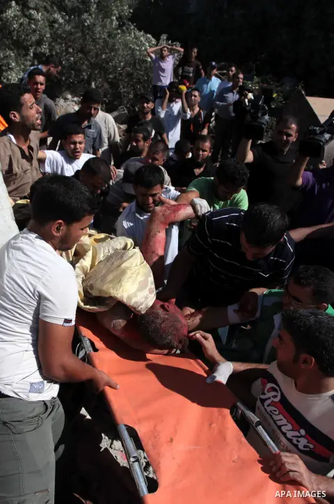 Emergency responders carry the body of a man, found under the rubble of his house following an Israeli airstrike in central Gaza Strip July 9, 2014. Israeli air strikes shook Gaza every few minutes on Wednesday, and mili...