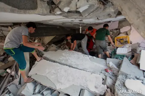 Palestinians inspect a house which police said was damaged in an Israeli air strike in Gaza City July 10, 2014. Israel pressed on with a punishing aerial offensive in Gaza for a third day on Thursday, killing eight membe...