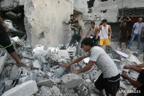 Smoke rises from buildings following what witnesses said was an Israeli air strike, as Palestinians search for victims under the rubble of a house which police said was destroyed in another Israeli air strike in Rafah in...