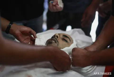Palestinians prepare tho body of Palestinian doctor Anas Abu al-Kas, 33, in the morgue of the al-Shifa hospital in Gaza City on July 11, 2014. Israeli warplanes kept up deadly raids on Gaza but failed to stop Palestinian...